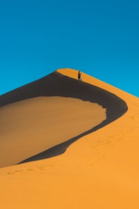 Woman hiking up the giant sand Dune 45, Namib-Naukluft National Park, Namibia Woman hiking up the giant sand Dune 45, Namib-Naukluft National Park, Namibia